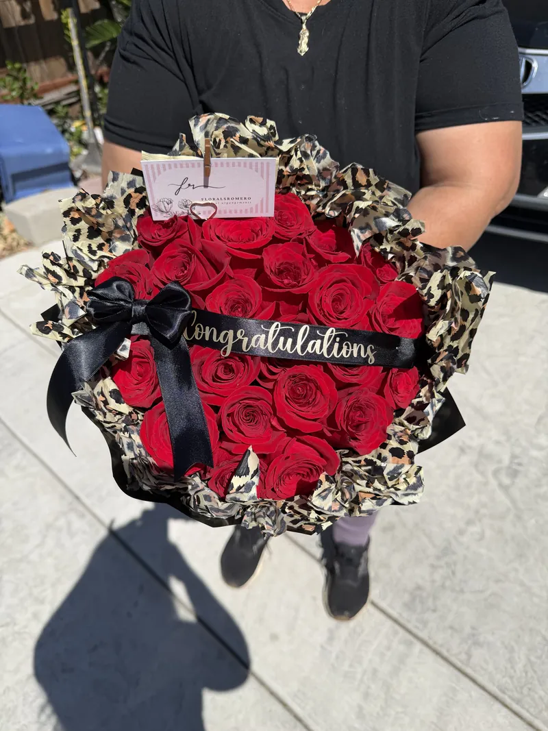 Deep red roses in a leopard-print wrap with a black satin bow and a Congratulations sash.