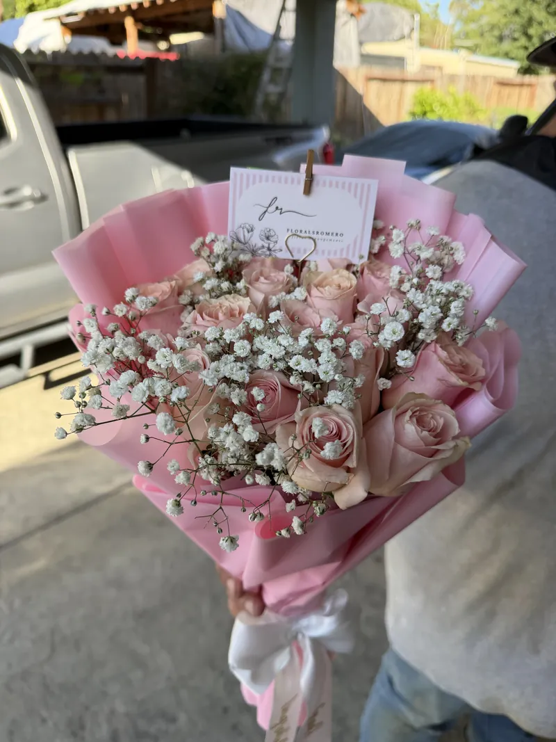 Pale pink roses and baby's breath in a rose-pink wrap.